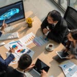 a group of people having a meeting with an automotive software on their computer