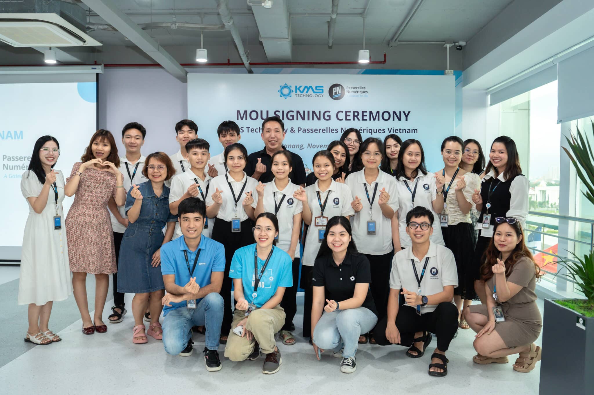 A group of people smiling taking a picture together at KMS Technology and Passerelles Numériques Vietnam's ceremony