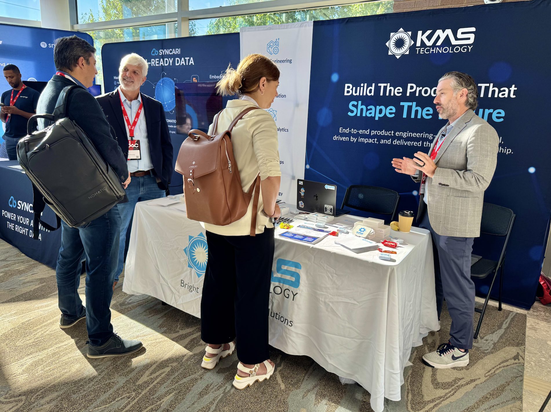 The KMS Team talks to prospects at the Data COLLIDE booth, discussing AI maturity and readiness.