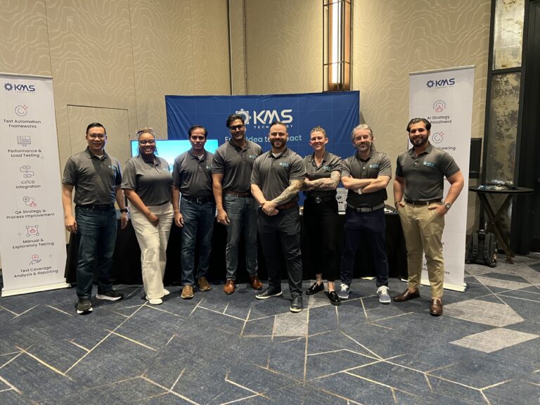 The KMS Technology teams poses in front of the AiPEX 2026 booth.